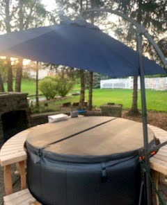 CHILLnTUB hot tub set up with cover, wooden steps, and optional wooden surround and umbrella.