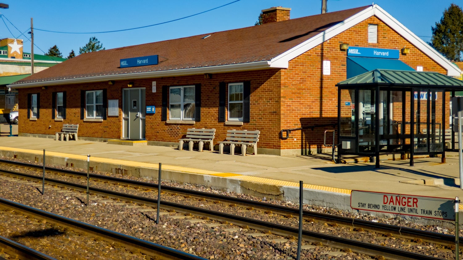 Harvard Metra station with covered shelter and benches.