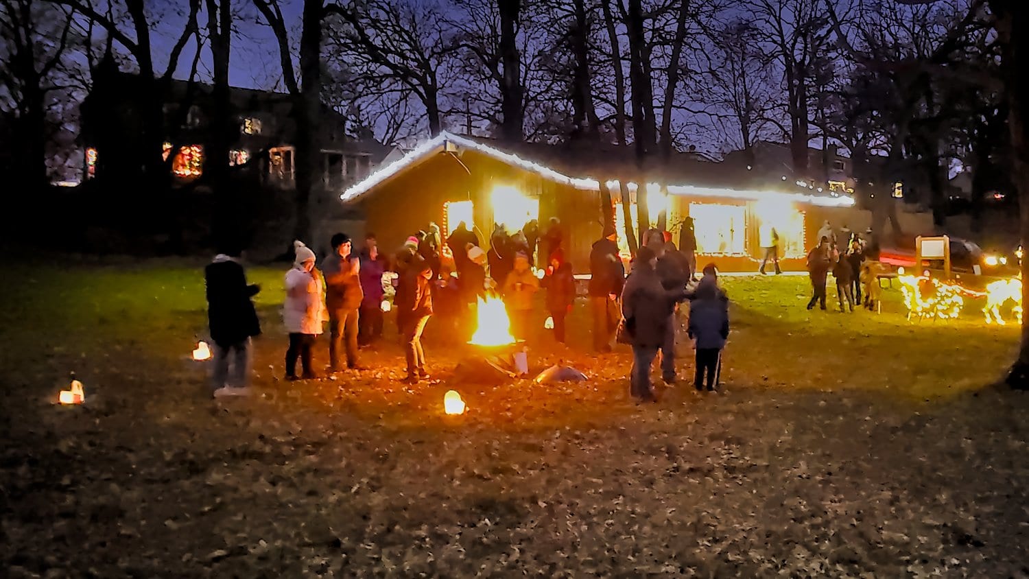 Walkers enjoying the lights and fire outside Oakwoods Lodge.