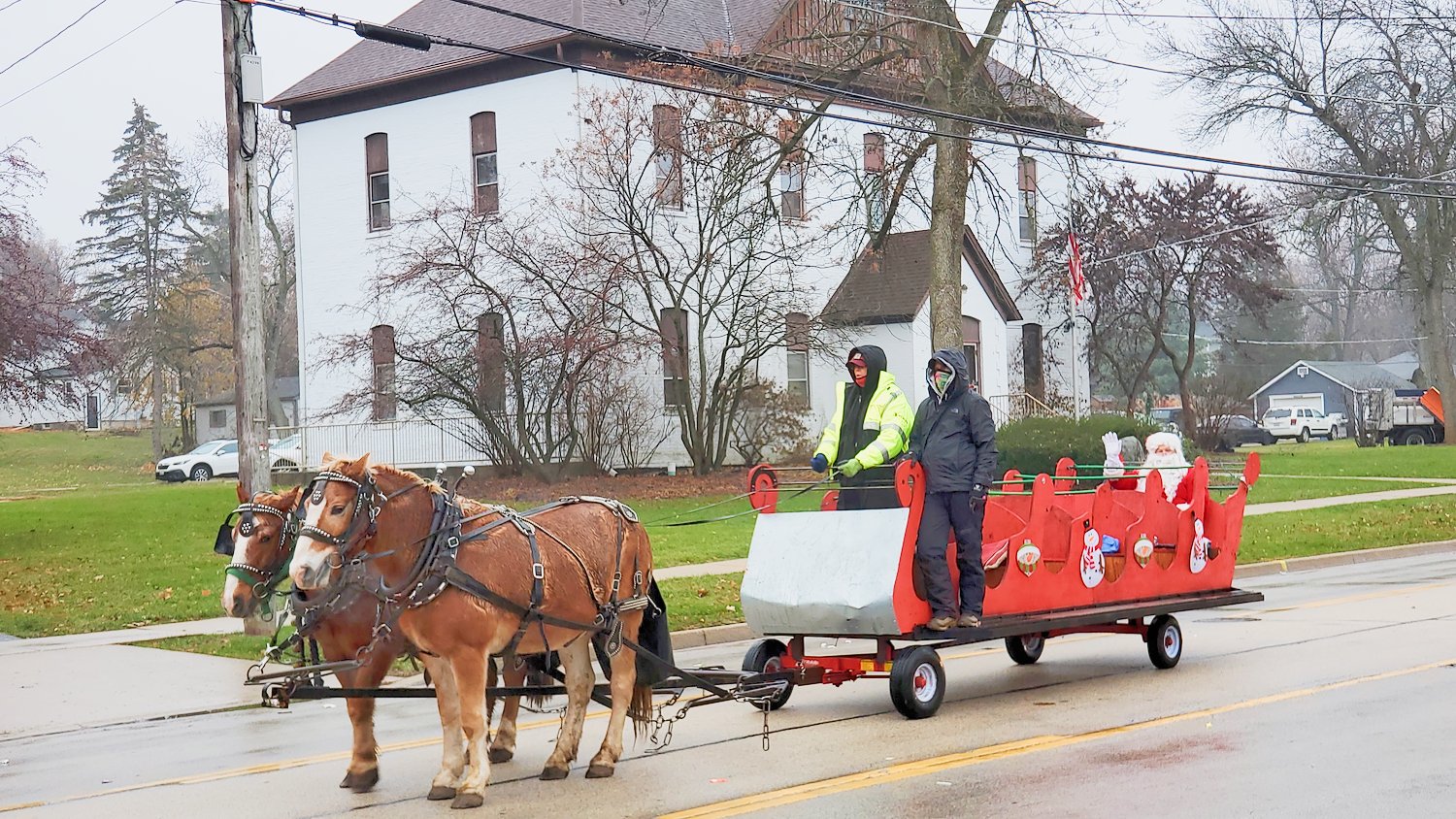 Horses pulling sleigh-trailer and Santa.