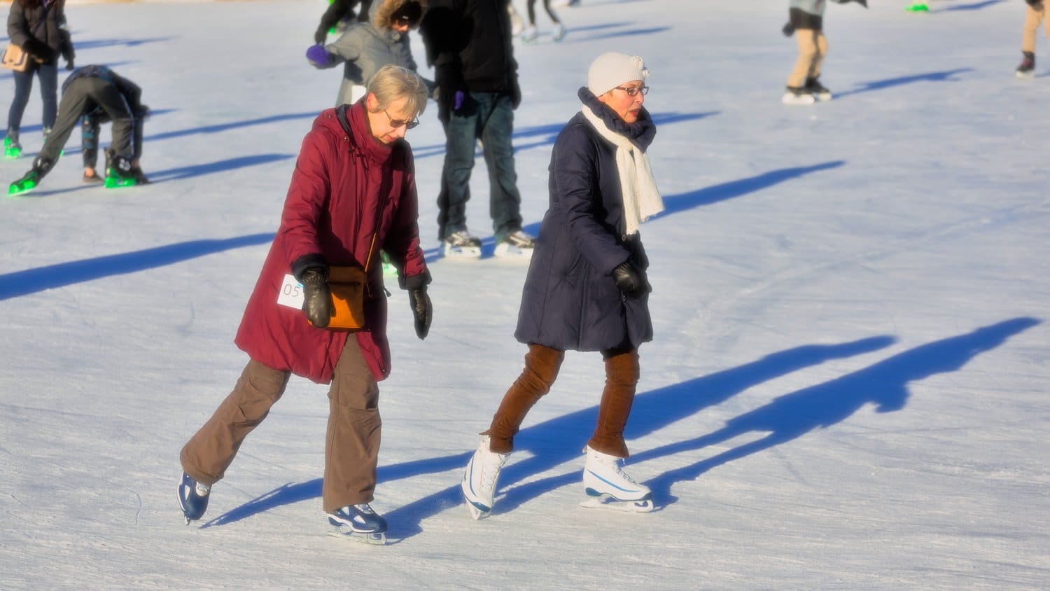 People ice skating outdoors.