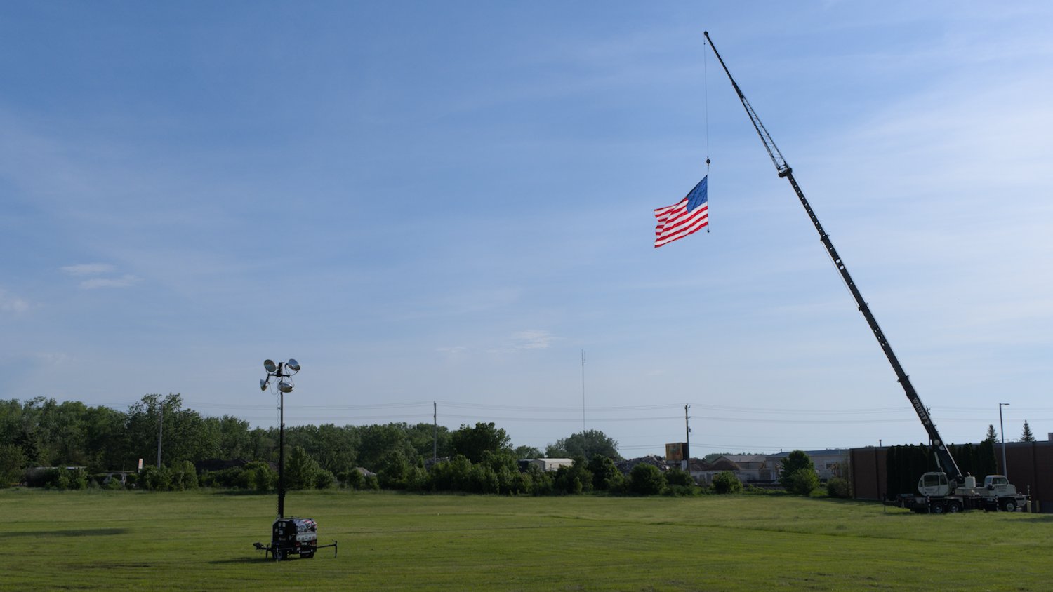 Large U.S. flag flying from crane.