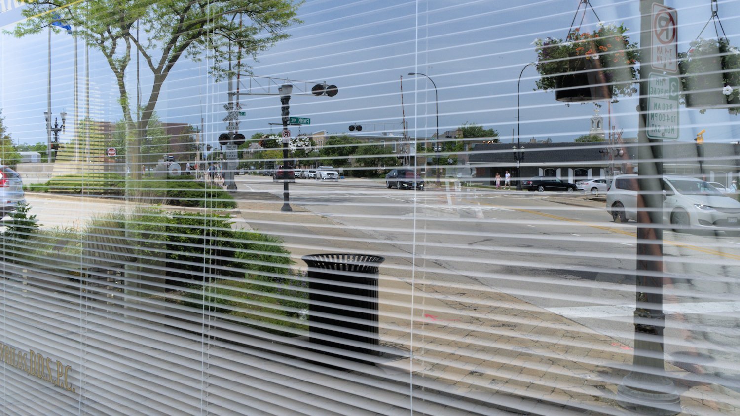 Reflection of traffic in office window with metal blind.