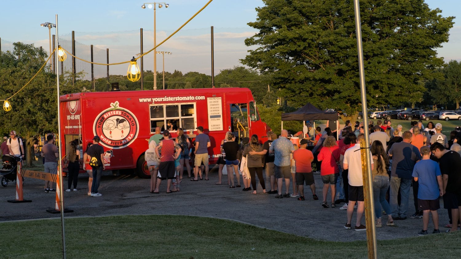 People lining up for wood-fired pizzas from Your Sister's Tomato food truck.