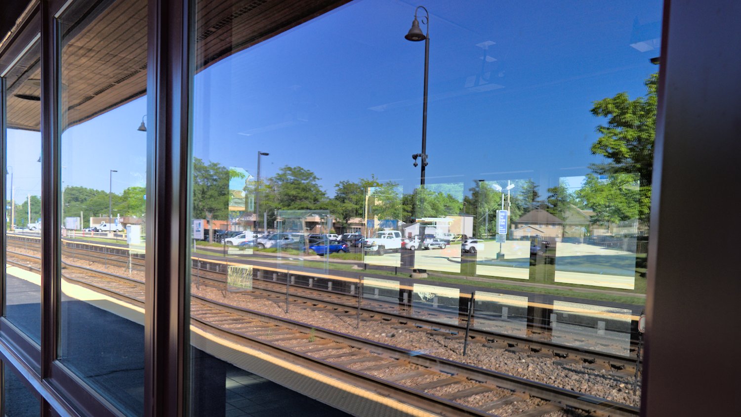 Reflections and pass-through view through the waiting shelter at the train station.