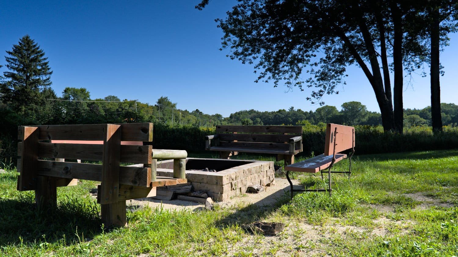 Benches and fire pit near the shelter at Sterne's Woods & Fen.