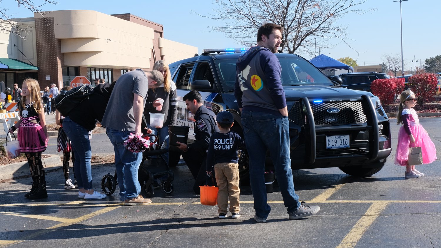Crystal Lake Police officer hands out candy to trick-or-treaters.