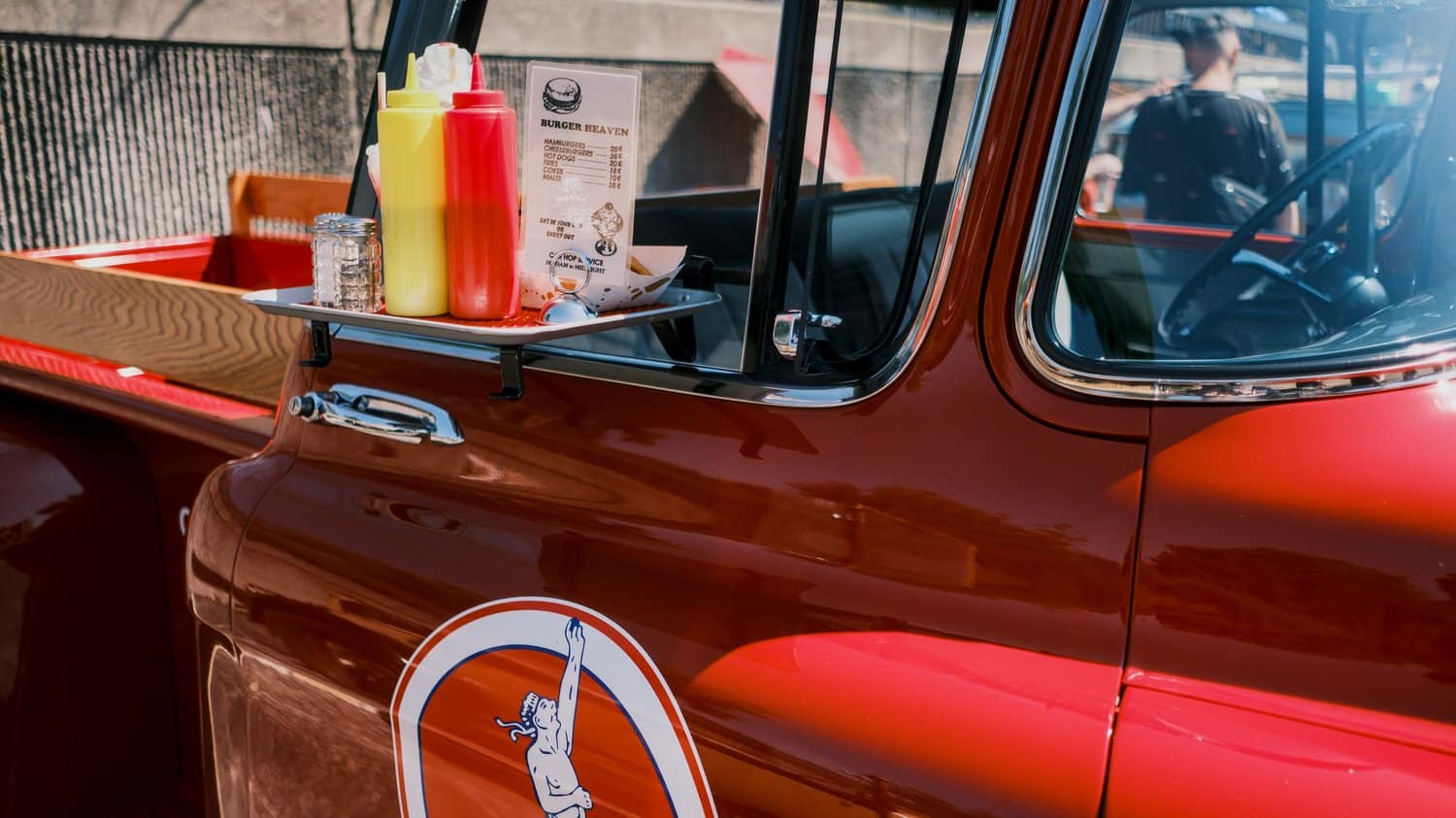 Vintage red pickup truck with car hop tray.
