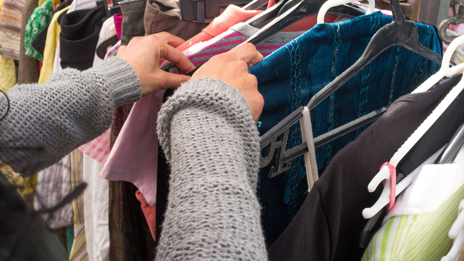 Woman sorting through a garage sale clothes rack