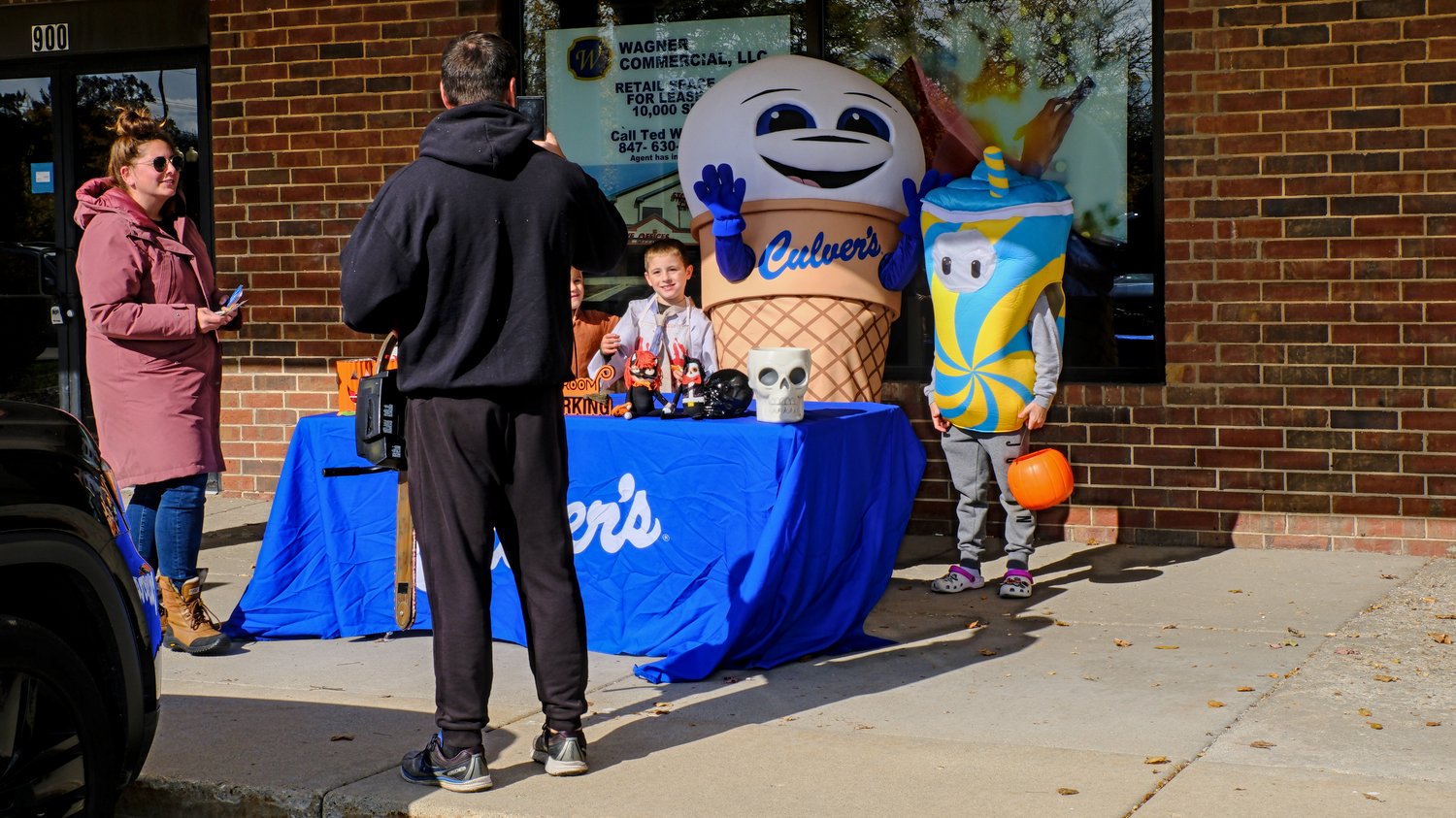 Taking picture of trick-or-treaters with Scoopie, Culver's mascot.