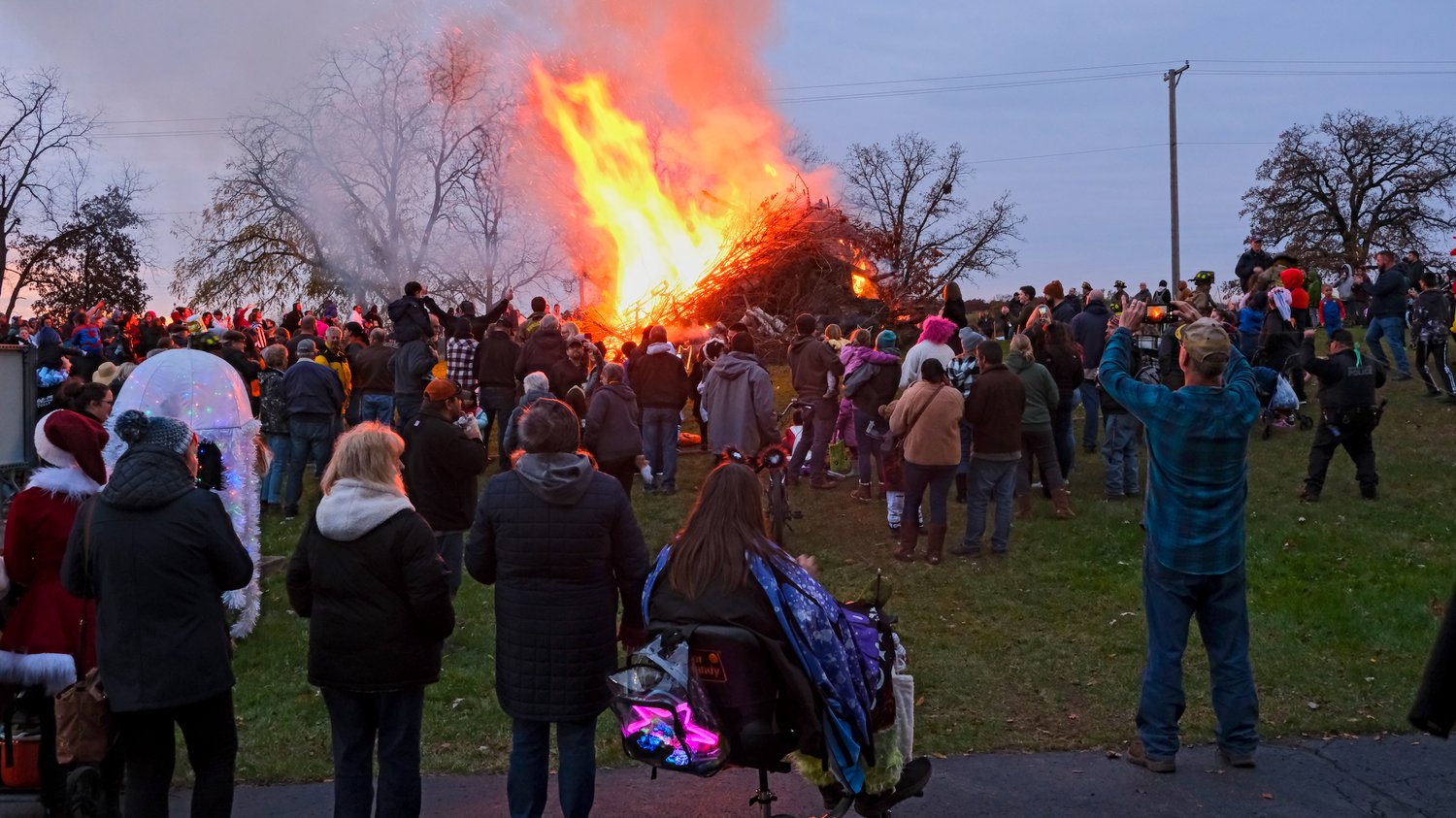 Crowd surrounds the bonfire.