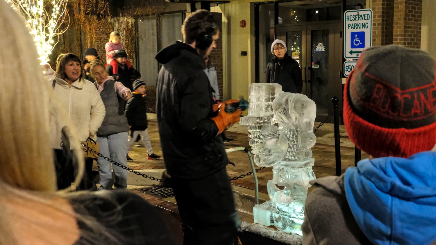 Ice sculptor carving an elf carrying packages.
