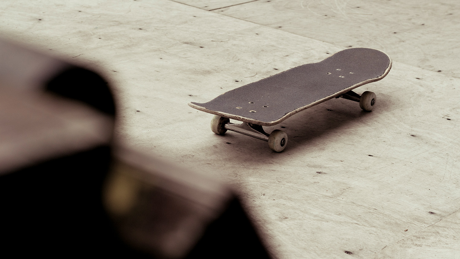 A skateboard sitting alone at a skate park.